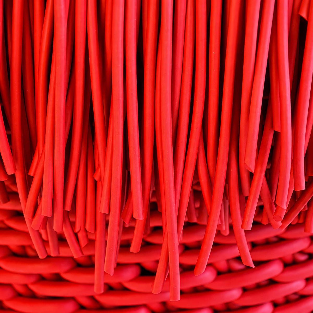 COVO Anemon Pouf by Rosanna Contadini. Layered red fabric strips create depth with rich crimson tones.