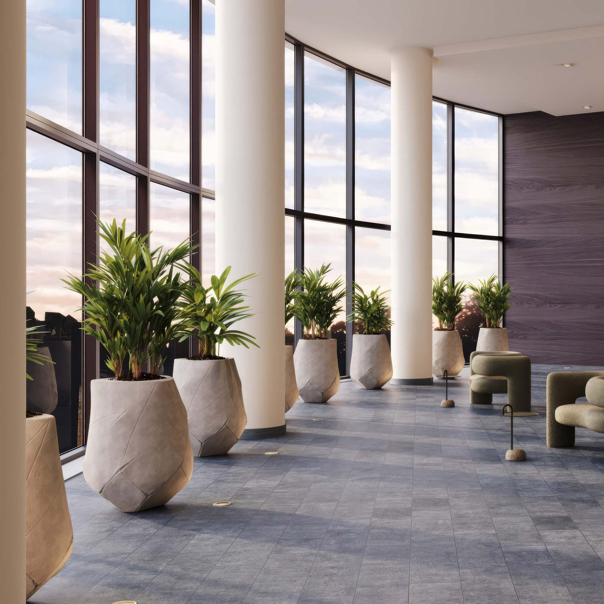Indigenus Bhaca by Andile Dyalvane. Modern corridor with tall windows, marble planters, and green plants.