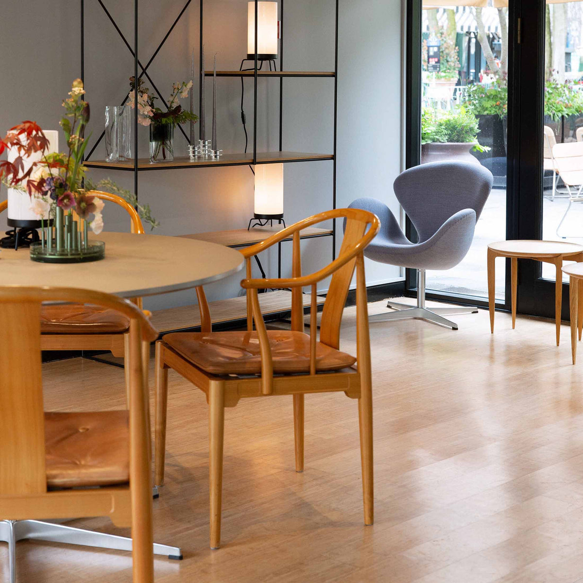Fritz Hansen China Chair™ by Hans J. Wegner. Warm wooden chairs surround a round table in a bright, modern space.