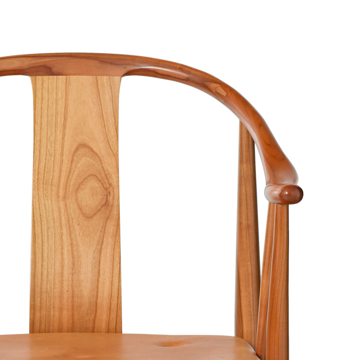 Fritz Hansen China Chair™ by Hans J. Wegner. A wooden chair features warm honey tones and smooth curved details.