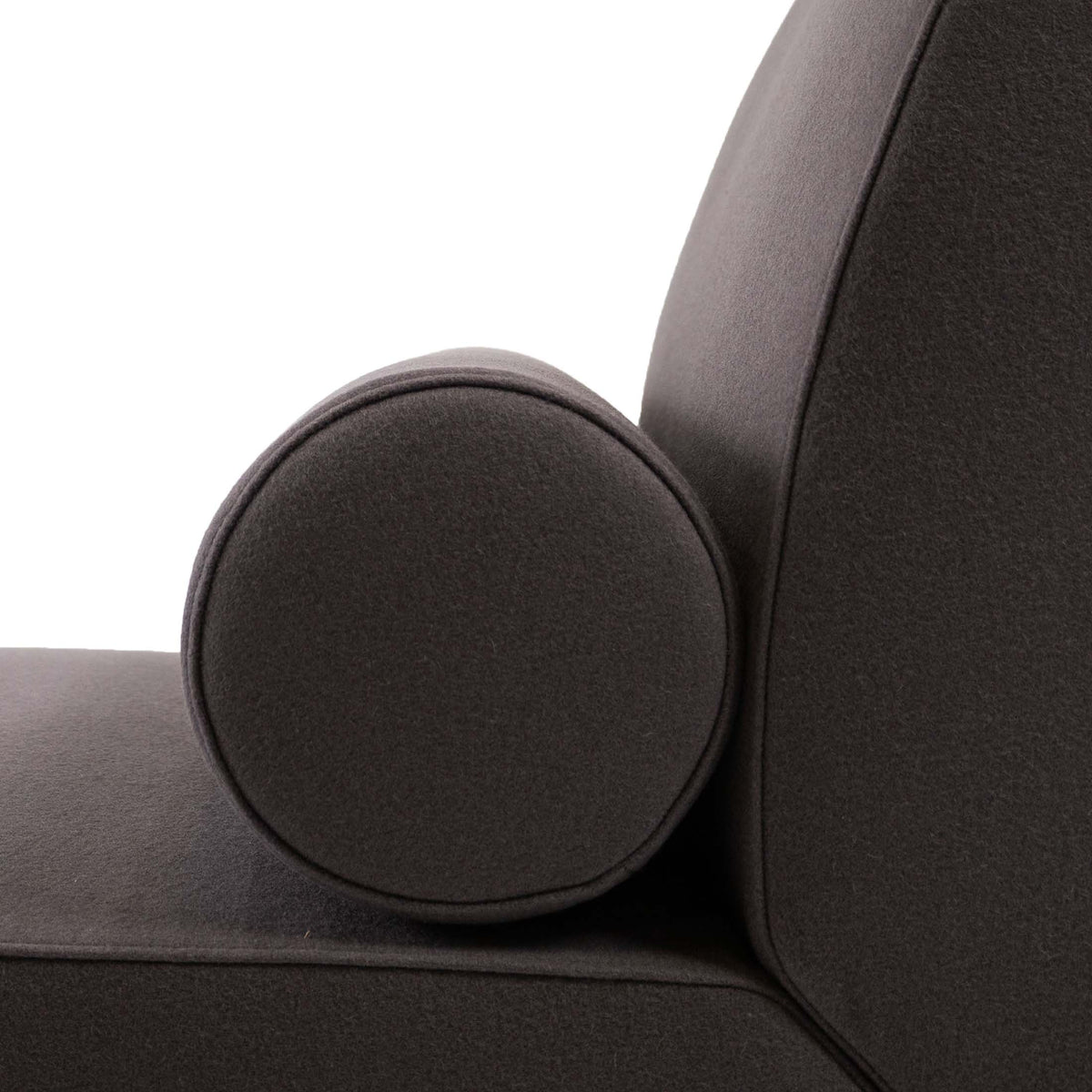 Cappellini Daybed by Jasper Morrison. A dark gray upholstered chair features a round decorative pillow.