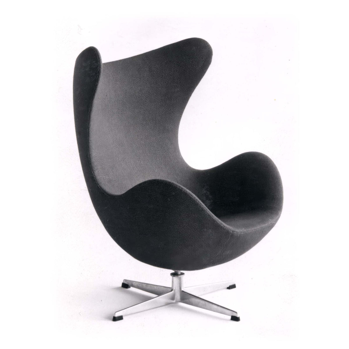 Fritz Hansen Egg™ Chair - 3316 by Arne Jacobsen. A sleek black chair with curved wool upholstery sits on a modern metal base.