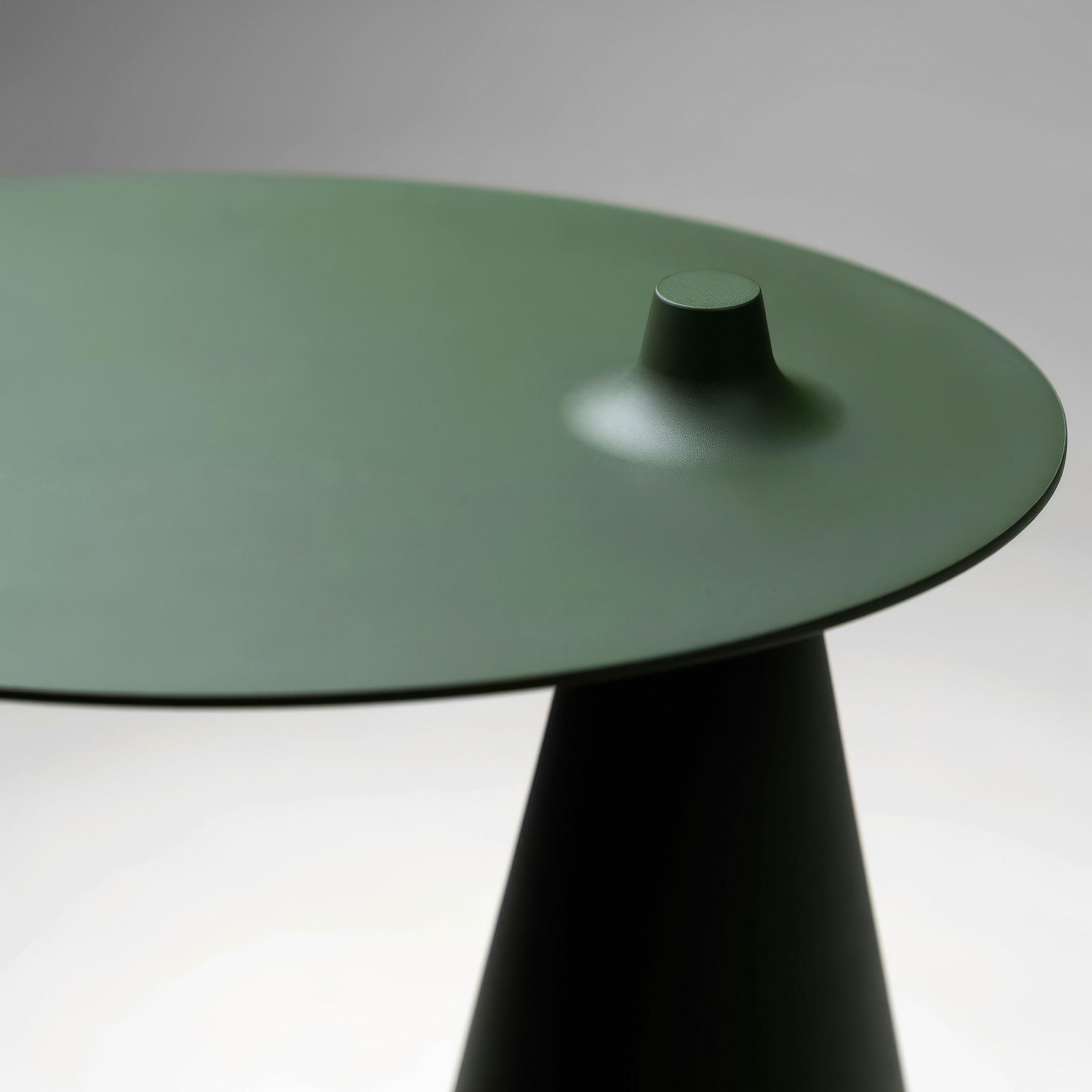 Established & Sons Fez Side Table by Nao Tamura. A minimalist table with a sage green glass top and dark conical base.