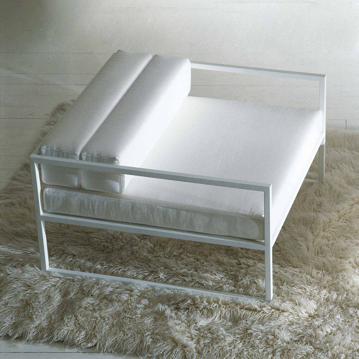 Cappellini Fronzoni '64 Armchair by AG Fronzoni 1964. White modern chair with rolled arms on a beige rug.