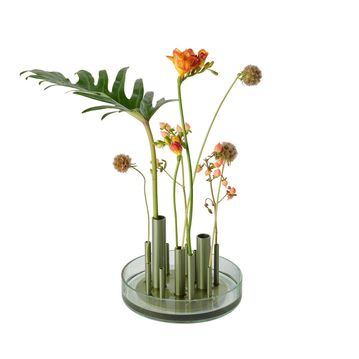 Fritz Hansen Ikeru™ Vase by Jaime Hayon. Orange flowers and green foliage arranged in glass tubes on a circular base.