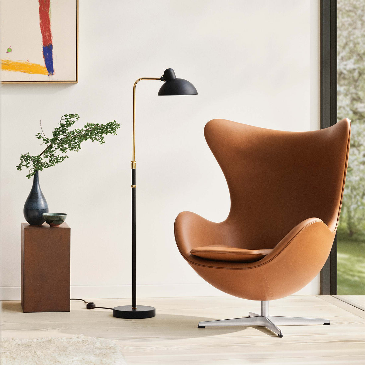 Fritz Hansen Kaiser Idell™ Floor Lamp by Christian Dell. Caramel leather chair with black arc lamp in minimalist interior.