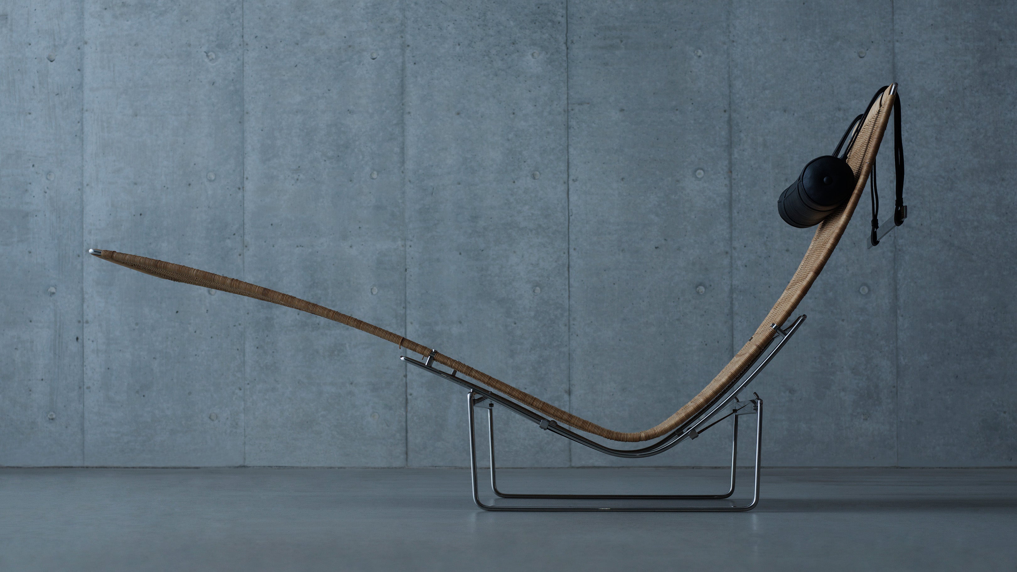 Desktop / PK24 Lounge Chair, designed by Poul Kjærholm and made by Fritz Hansen