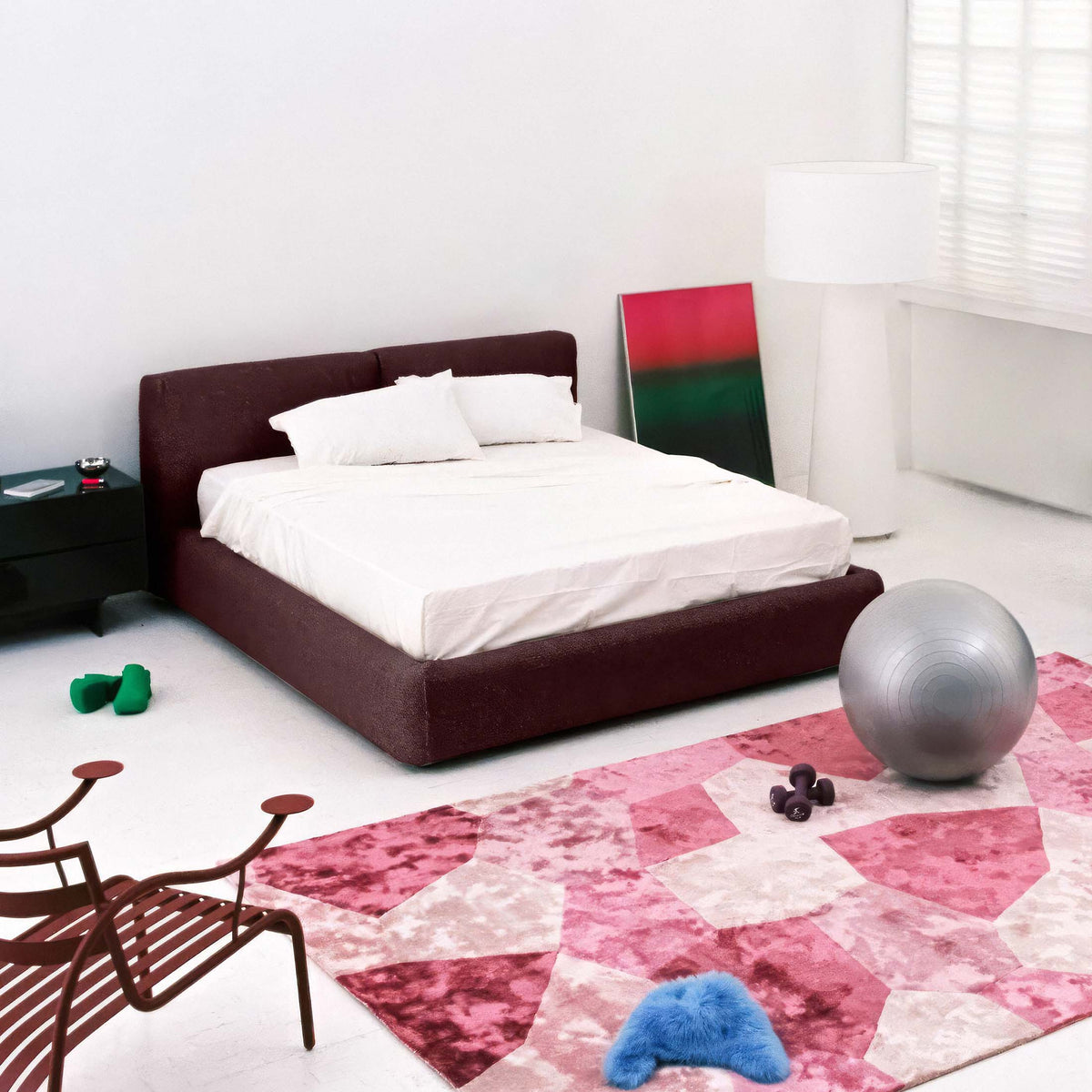 Cappellini Oblong Plus Bed by Jasper Morrison. A burgundy upholstered bed with white bedding sits in a minimalist bedroom.