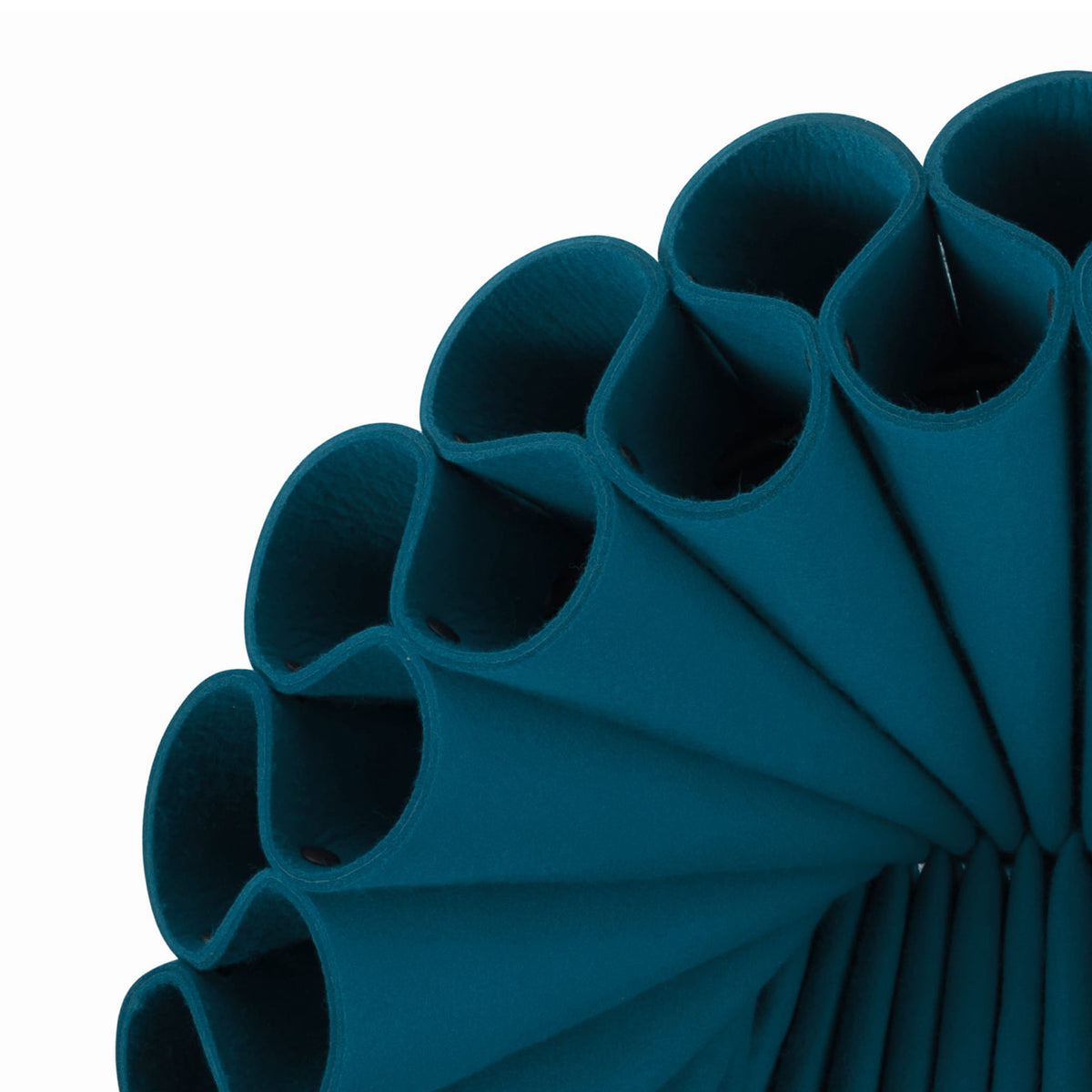 Cappellini Peacock by Dror. Rolled teal fabric tubes with soft texture arranged in a diagonal pattern against white.