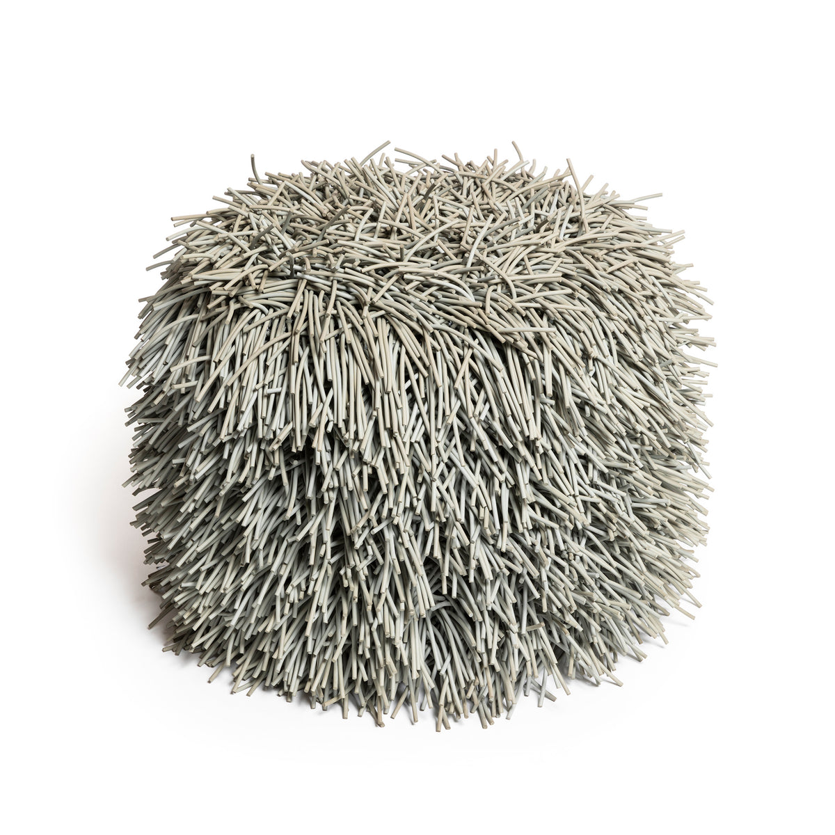 COVO Porcupine Pouf by Rosanna Contadini. A spherical ball of thin, tan-colored straw or dried grass strands.