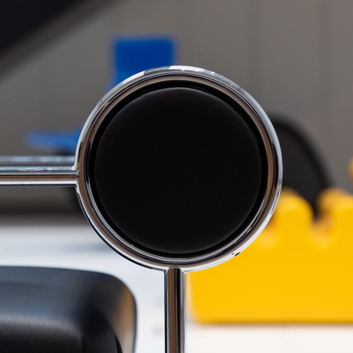 Cappellini Sofa with Arms by Shiro Kuramata. A chrome-rimmed circular mirror reflects dark liquid in a bright workspace.