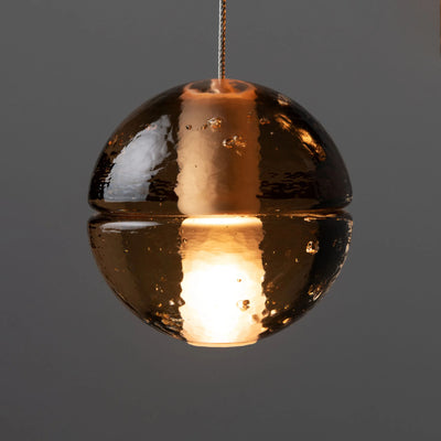 Bocci 14.20 Random by Omer Arbel. A gleaming copper sphere pendant glows warmly against gray.