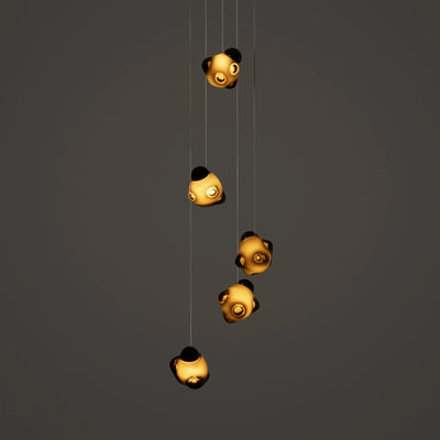Bocci 57.5 Random by Omer Arbel. Five golden spheres with black accents hang from thin wires against a gray background.