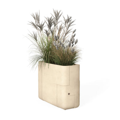 Indigenus Aarde by Sebastian Herkner. A cream-colored textured planter holds ornamental grasses with feathery plumes.
