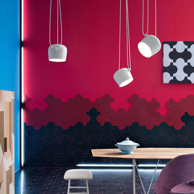 Flos Aim Suspension Lamps by Erwan & Ronan Bouroullec. White pendant lamps hang against a vibrant red wall.