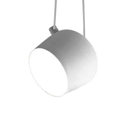 Flos Aim Suspension Lamps by Erwan & Ronan Bouroullec. A sleek gray pendant lamp hangs from wires above.