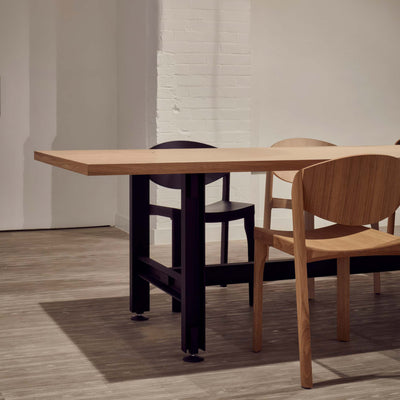 Established & Sons Beam Table by Konstantin Grcic. A light wood table with black legs sits in a minimalist white space.