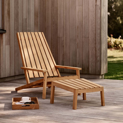 Fritz Hansen Between Lines Deck Stool by Stine Weigelt. Natural wood lounge chair and ottoman on a patio.