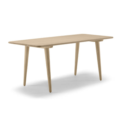 Carl Hansen & Søn CH011 Coffee Table by Hans J. Wegner. A light wood table with tapered legs and rounded edges.