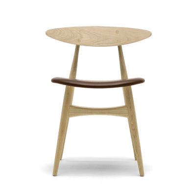 Carl Hansen & Søn CH33P Chair by Hans J. Wegner. Light wood chair with dark brown curved backrest and angled legs.
