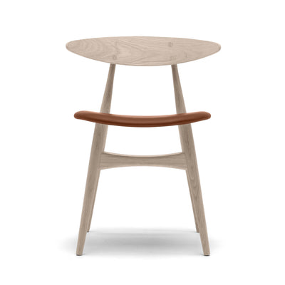 Carl Hansen & Søn CH33P Chair by Hans J. Wegner. A light wood chair features a brown leather backrest and tapered legs.
