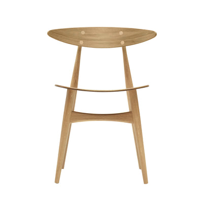 Carl Hansen & Søn CH33T Chair by Hans J. Wegner. A light wood table with an oval top and tapered legs in a minimalist design.
