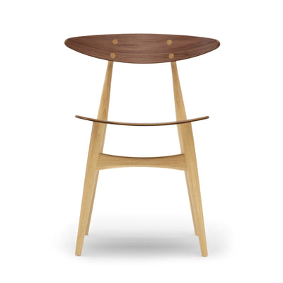 Carl Hansen & Søn CH33T Chair by Hans J. Wegner. A mid-century modern wooden stool with a walnut top and light oak legs.