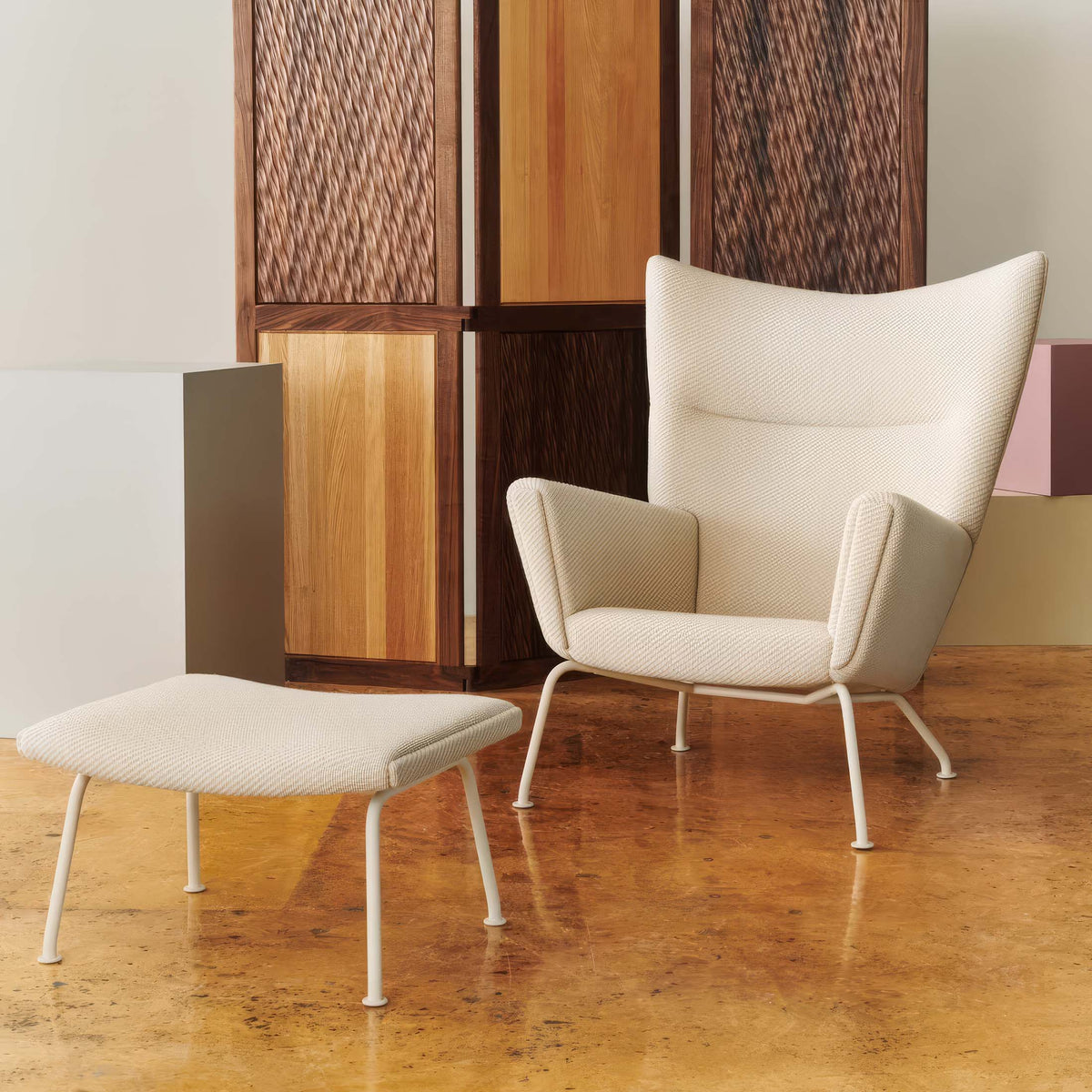 Carl Hansen & Søn CH445 Wing Chair by Hans J. Wegner. Cream fabric chair and ottoman with white metal legs.