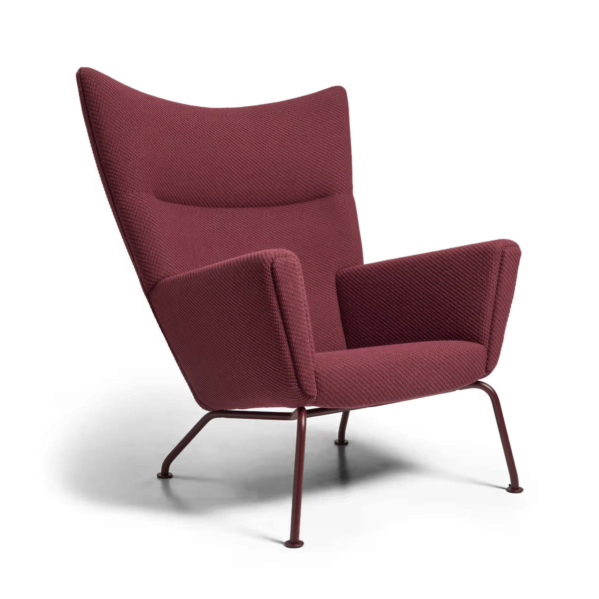Carl Hansen & Søn CH445 Wing Chair by Hans J. Wegner. A burgundy fabric wingback chair with metal legs.