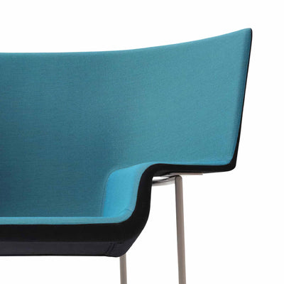 Cappellini Capo by Doshi Levien. A turquoise fabric chair with black trim and metallic legs against a white background.