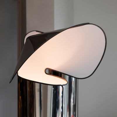 Flos Chiara Floor by Mario Bellini. A sleek chrome lamp with curved frosted glass shade emits warm light.