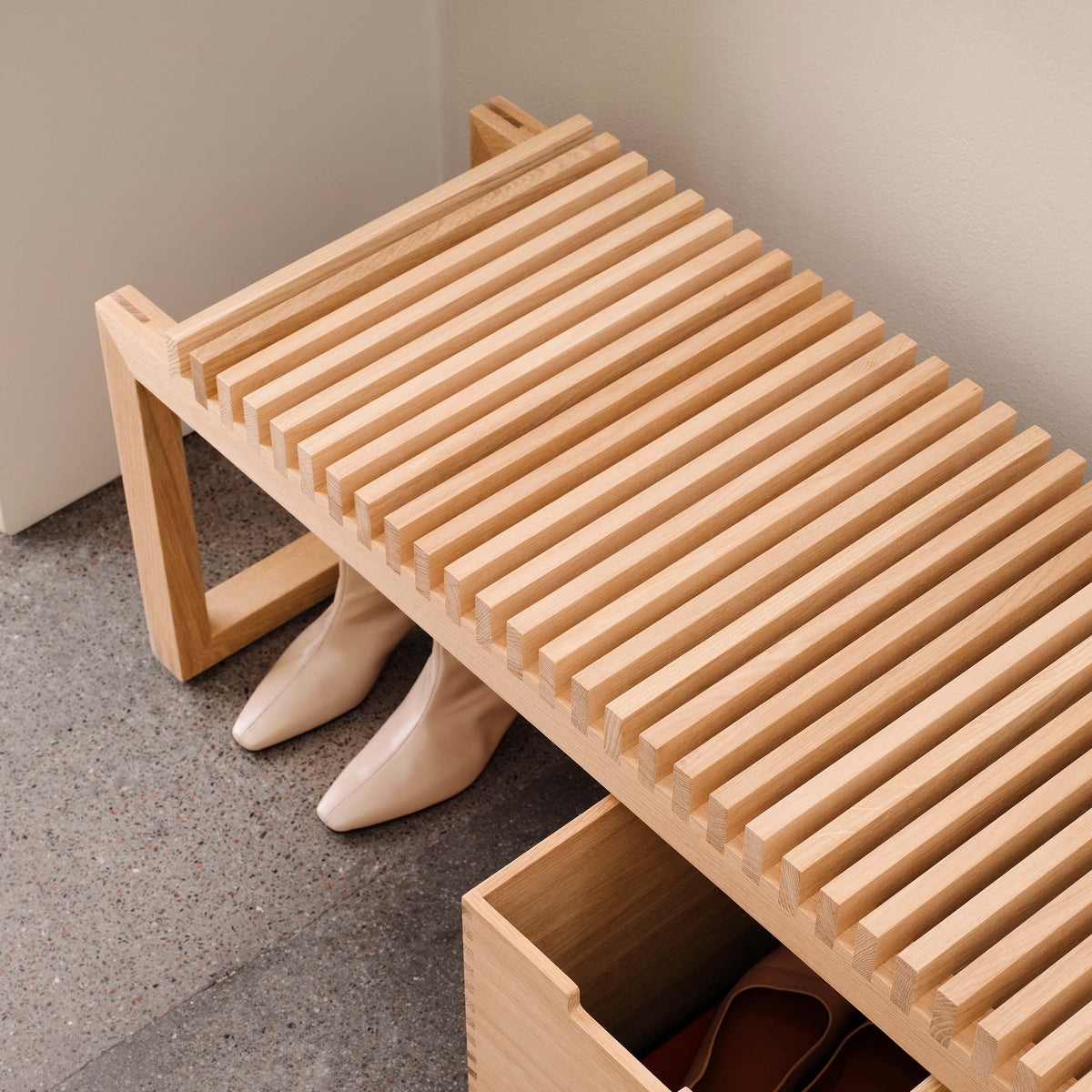 Fritz Hansen Cutter Bench by Niels Hvass. Light wood bench with slatted seat and storage drawer underneath.