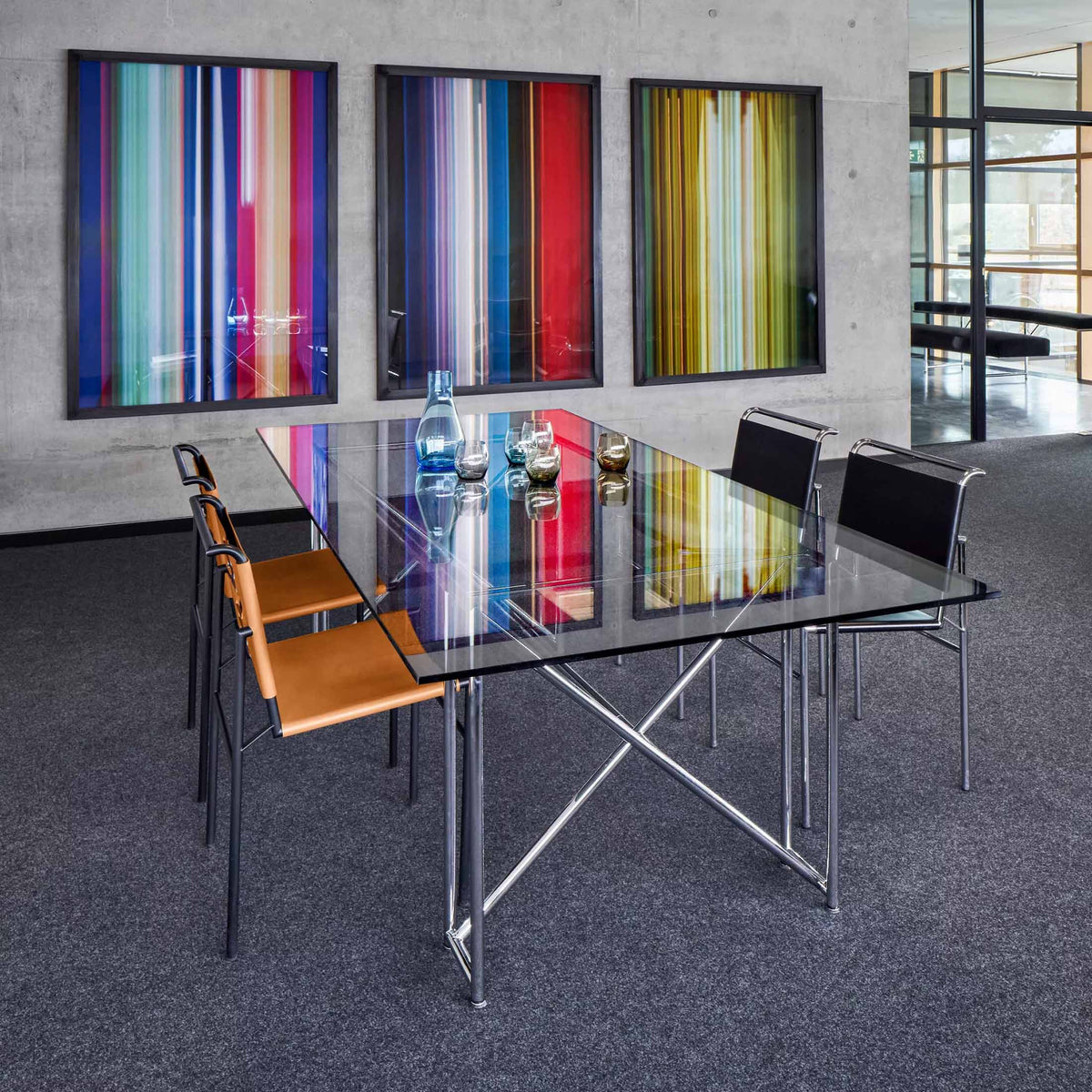 ClassiCon Double X by Eileen Gray. Modern conference room with colorful striped artwork and glass table.
