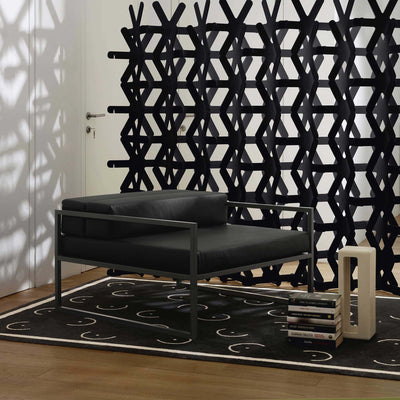 Cappellini Fronzoni '64 Armchair by AG Fronzoni 1964. Black leather chair with metal frame against geometric wall art.