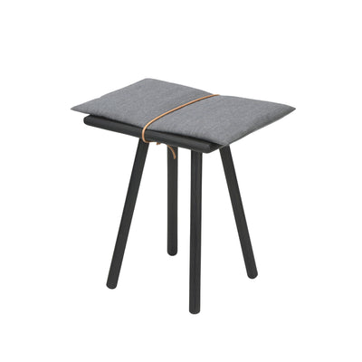 Fritz Hansen Georg Bench by Chris Liljenberg Halstrøm. Gray cushioned seat with tan strap on black legs.