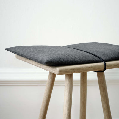 Fritz Hansen Georg Bench by Chris Liljenberg Halstrøm. Light wood stool with gray cushion and black trim.