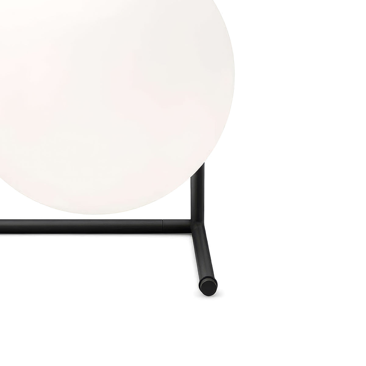 Flos IC Lights T2 by Michael Anastassiades. A frosted white globe rests on a sleek black metal stand.