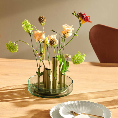 Fritz Hansen Ikeru™ Vase by Jaime Hayon. Colorful fresh flowers arranged in a modern glass vase on wood.