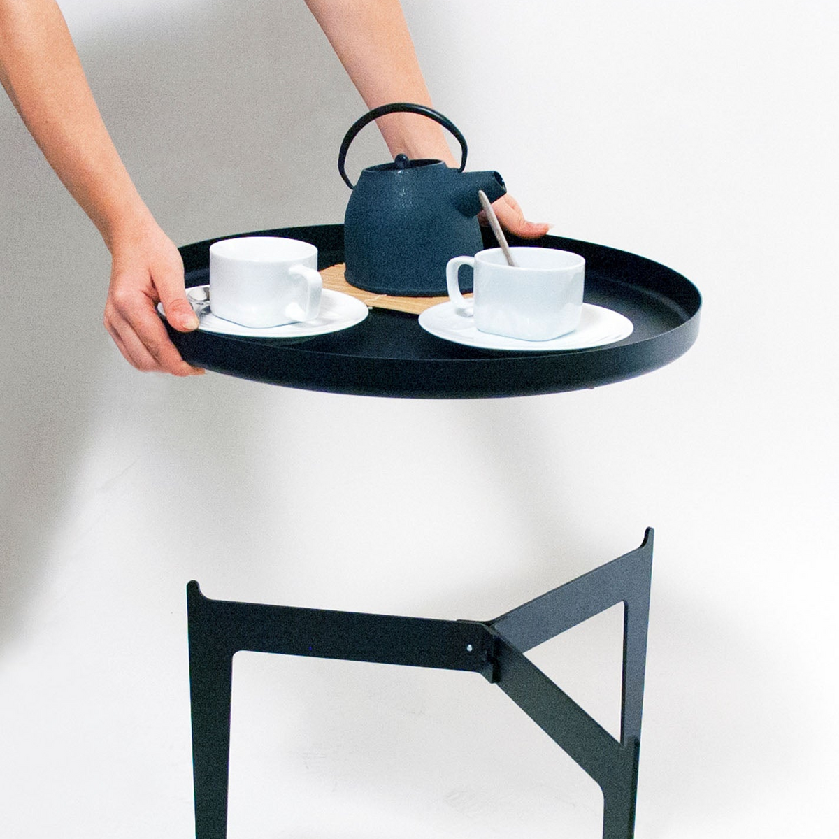 COVO Illusion - Two in One by Minna Niskakangas. A black tray holds white cups and a dark teapot with minimalist style.