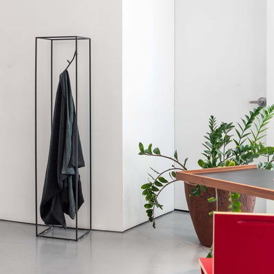 Cappellini Koeda by Nendo. A minimalist black metal frame holds a draped dark fabric in a bright, modern interior.