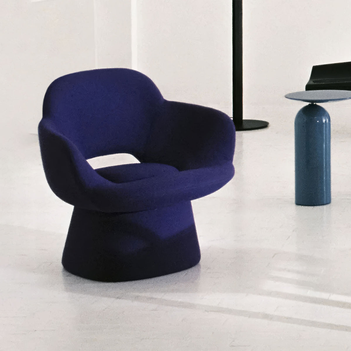 Cappellini Kwado by Sebastian Herkner. A deep blue sculptural chair sits in a minimalist space with modern accents.