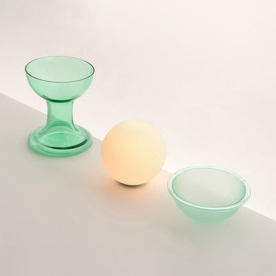 Established & Sons Gelato Lamp by Carlo Nason. Three glass objects in mint green and a glowing peach sphere on white surface.