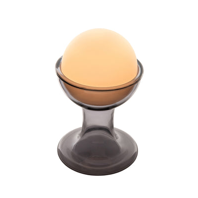Established & Sons Gelato Lamp by Carlo Nason. A glowing amber sphere rests in a smoky gray glass pedestal base.