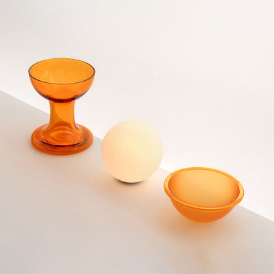 Established & Sons Gelato Lamp by Carlo Nason. Three orange glass vessels and a cream sphere sit on a white surface.