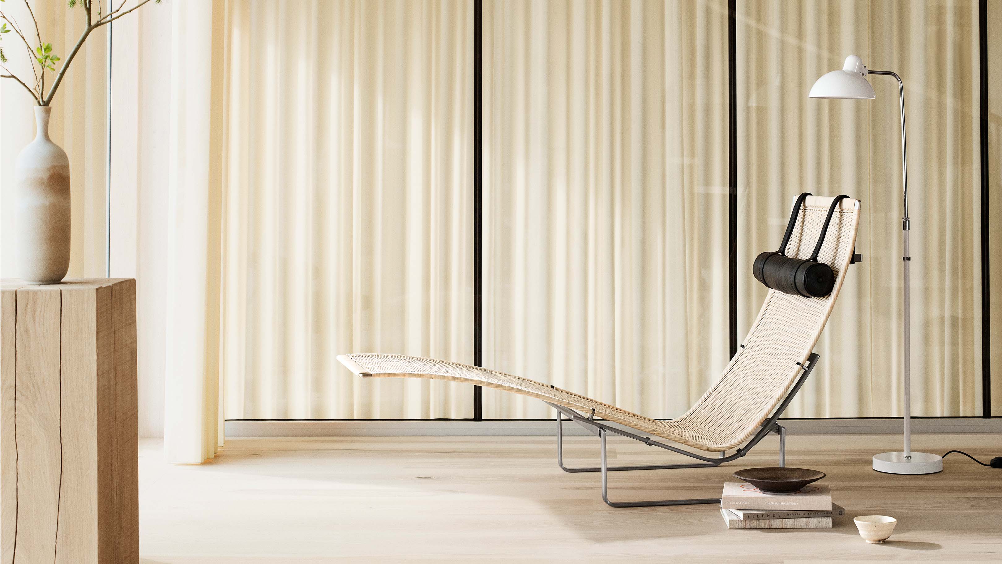 Desktop / PK24 Lounge Chair, designed by Poul Kjærholm and made by Fritz Hansen