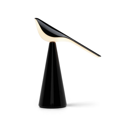 Established & Sons Tiki Table Lamp by Nao Tamura. A sleek black cone base supports a curved cream and black bird-shaped lamp.