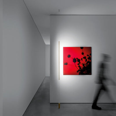 Davide Groppi Masai Floor Lamp by Maurizio Mancini. A vibrant red artwork hangs in a minimalist white gallery space.