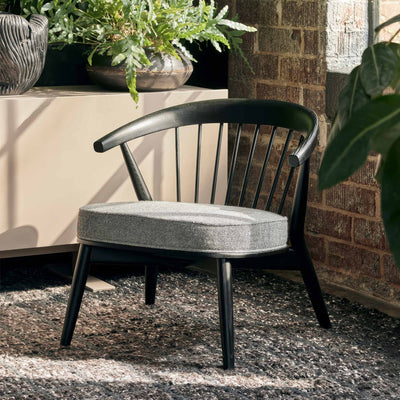 Cappellini Newood Relax by BrogliatoTraverso. A black wooden chair with a grey cushioned seat sits in a sunny garden patio.