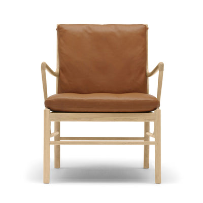 Carl Hansen & Søn OW149 Colonial Chair by Ole Wanscher. A tan leather chair with light wood frame sits against white.