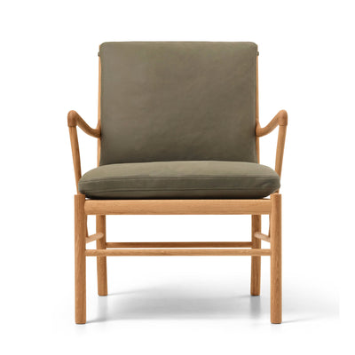 Carl Hansen & Søn OW149 Colonial Chair by Ole Wanscher. A wooden chair with gray upholstered cushions and curved armrests.